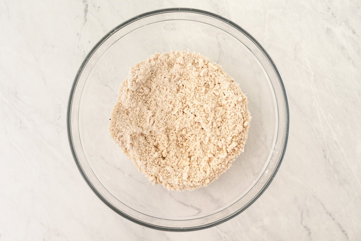 The flour mixture after cold butter has been cut in, with a coarse, crumbly texture.