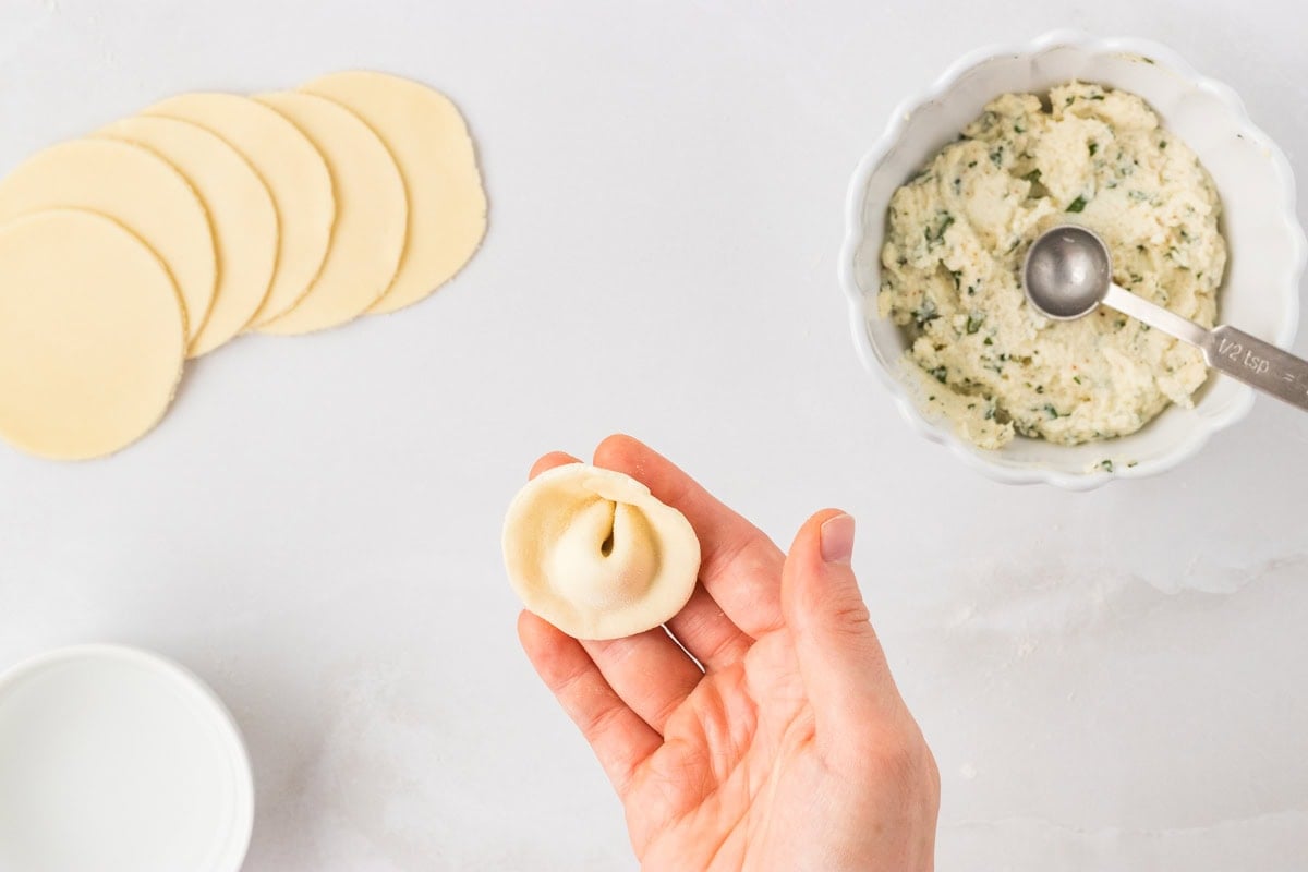 Fully shaped gluten-free tortellini with sealed edges and center pressed into the classic ring shape