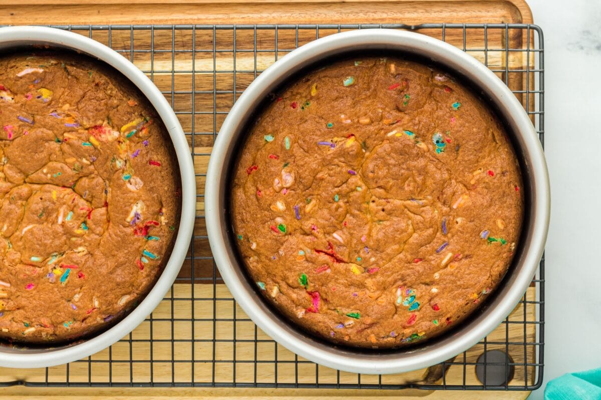 A detailed top view of the baked gluten-free funfetti cake, showing the browned crust and melted rainbow sprinkles.