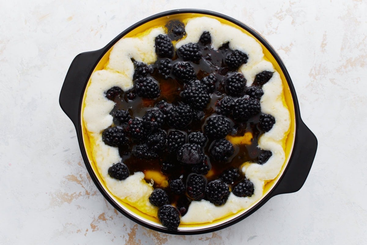 Fresh blackberries added on top of the batter in the dish, ready to be baked.