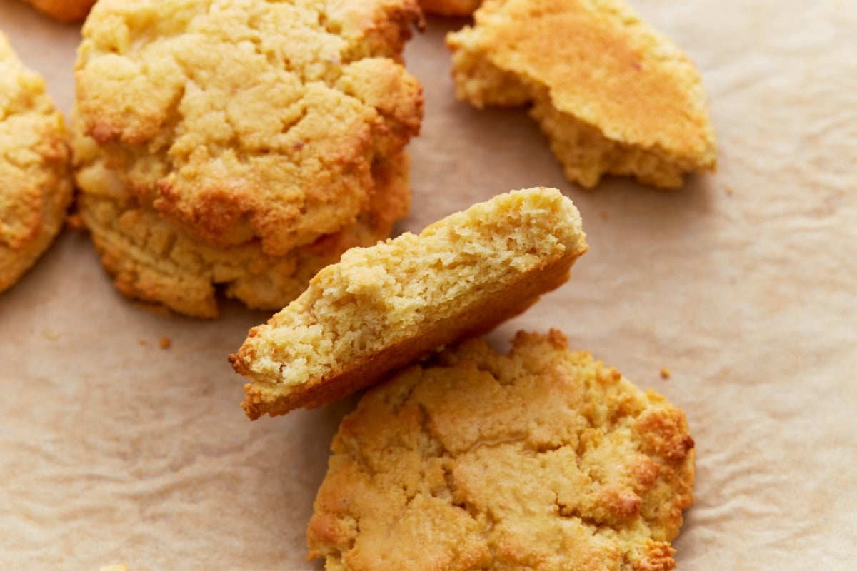Close-up of a biscuit broken in half, showing the soft, fluffy interior texture with crisp golden edges.