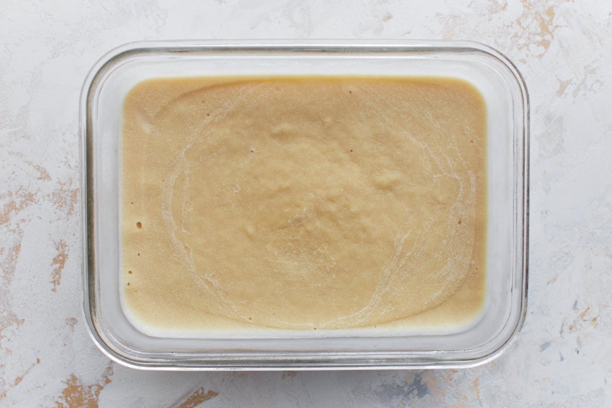 Frozen almond milk ice cream in a glass container, smooth and set after freezing.