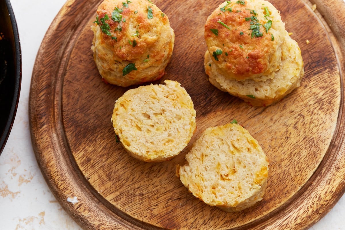 Biscuits halved to show the fluffy, tender interior with melted cheese and golden crust.