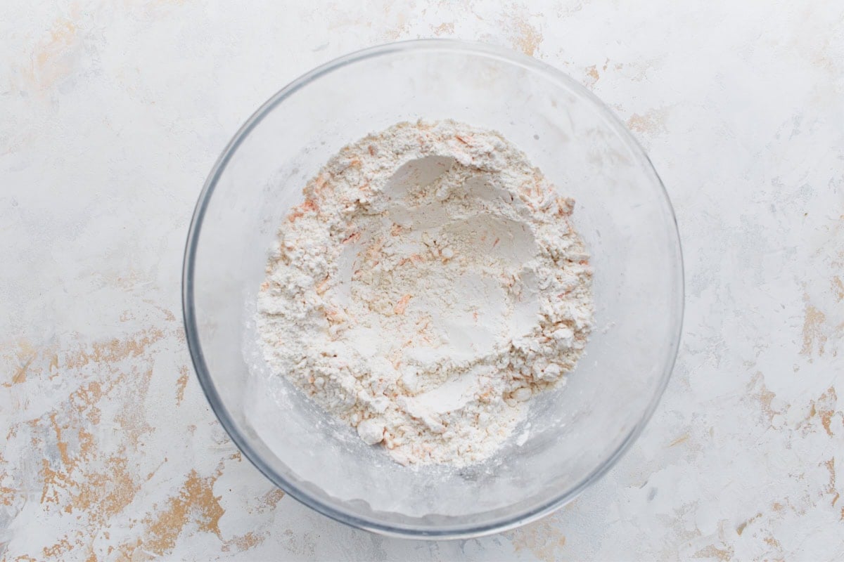 Flour mixture with added sharp cheddar cheese, ready to be turned into biscuit dough.