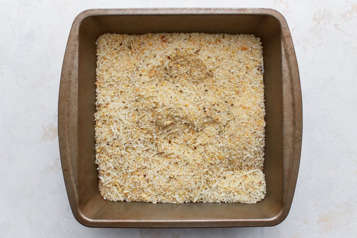 Gluten-free breadcrumb and Parmesan mixture with Italian seasoning in a metal dish, ready for breading.