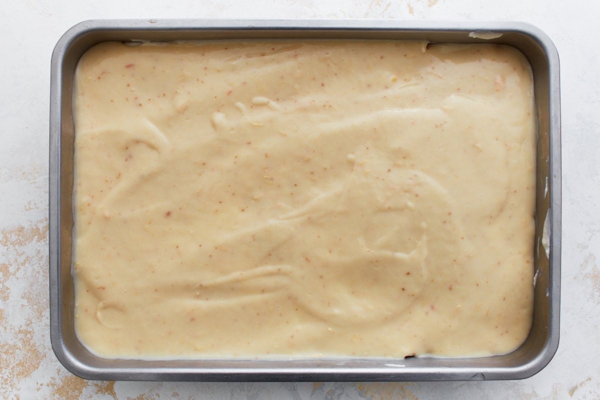 Final layer of the casserole with the creamy soup mixture spread over the Bisquick batter in a metal baking pan.