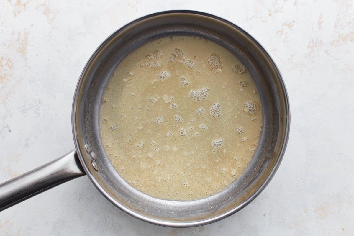 A saucepan with a light golden gluten-free roux made from oil and flour bubbling gently.