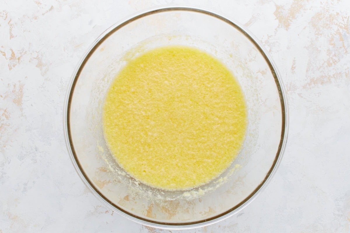 Wet ingredients, including lemon zest and butter, combined in a mixing bowl.