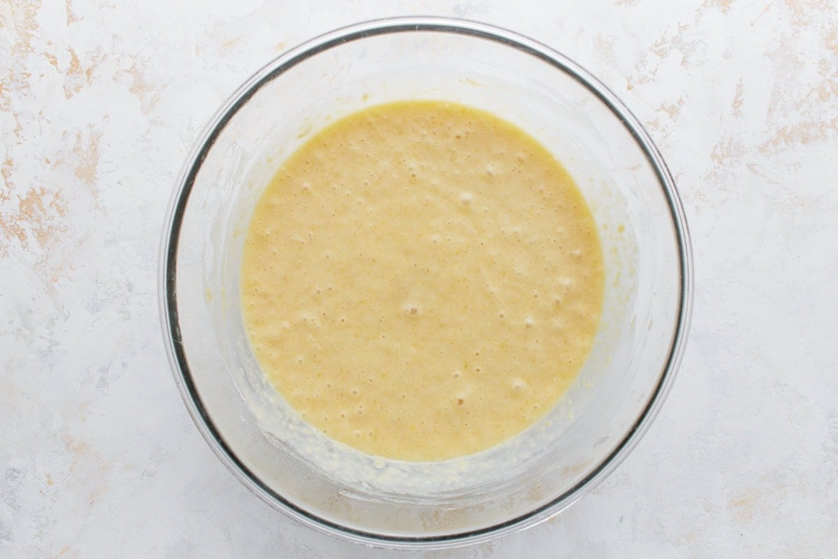 Fully mixed lemon loaf batter in a glass bowl, smooth and ready to pour.