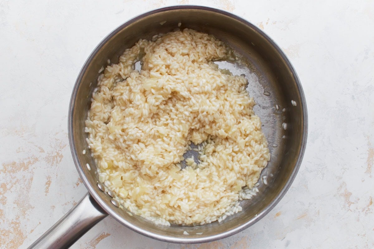 Risotto mixture starting to become creamy as it simmers in the pan