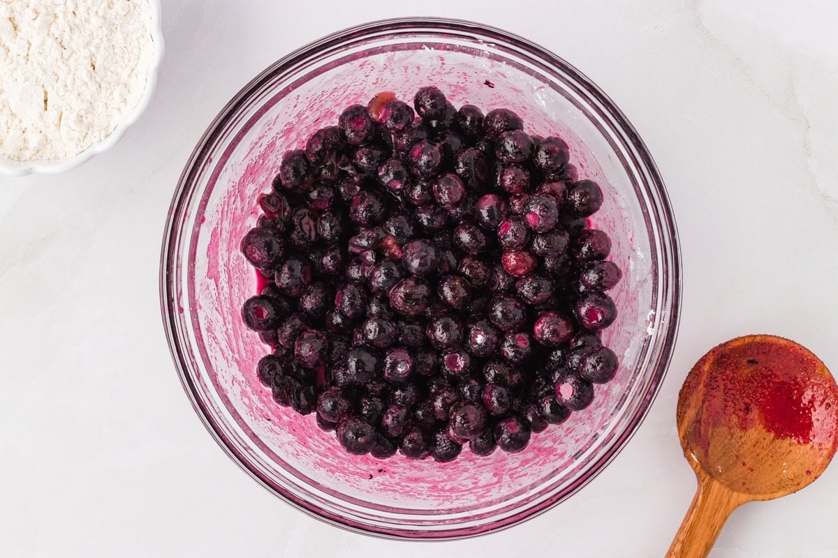 Fresh or frozen blueberries tossed with sugar, lemon juice, and cornstarch in a glass mixing bowl.