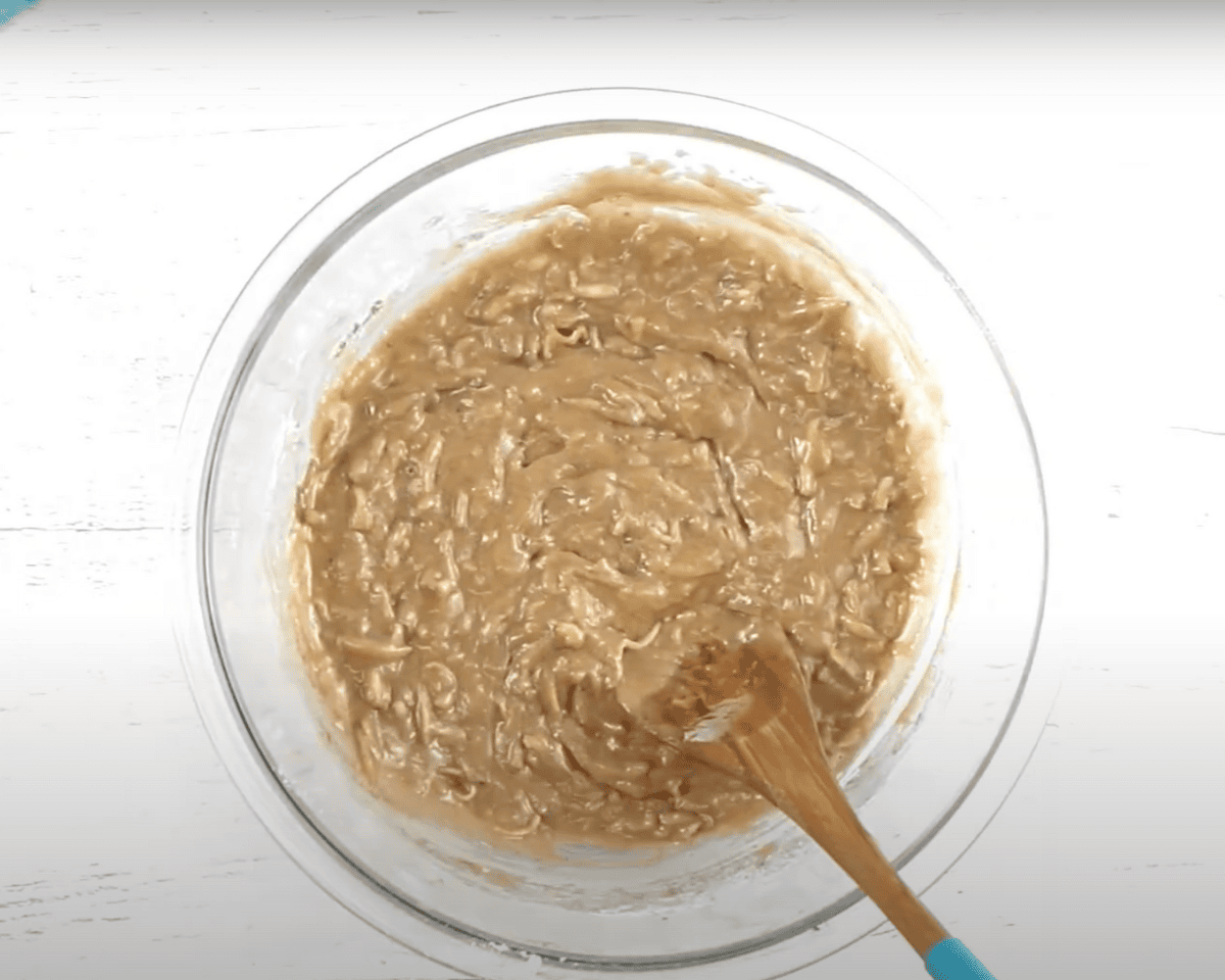 Fully mixed zucchini muffin batter with visible shredded zucchini, ready to scoop.