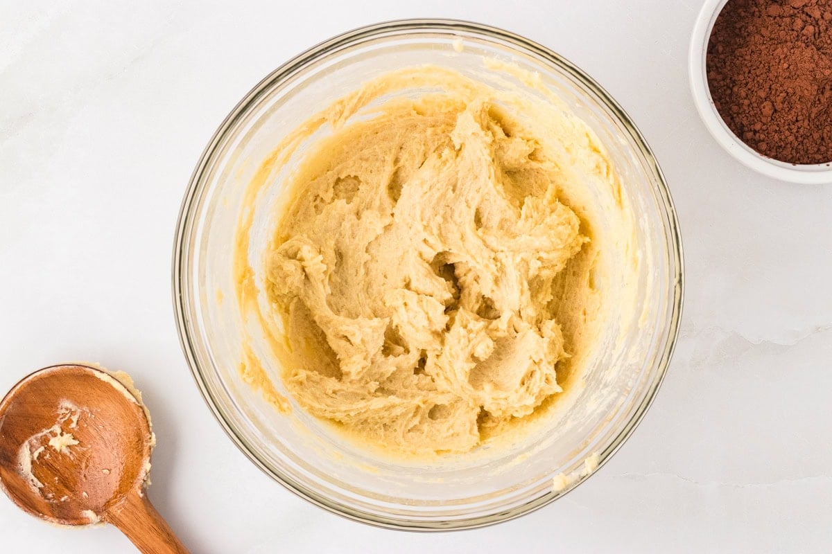 A bowl of light and fluffy creamed butter, granulated sugar, and brown sugar, mixed until smooth.