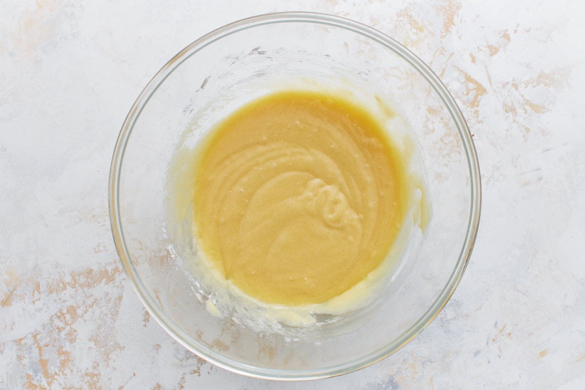 Smooth, mixed batter in a clear glass bowl, ready to be spread over the apple filling.