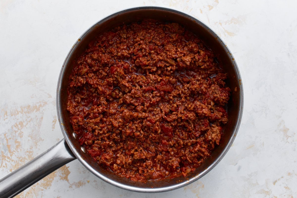 Keto chili after a long simmer, thickened with a rich, meaty texture and deep color in a large skillet.