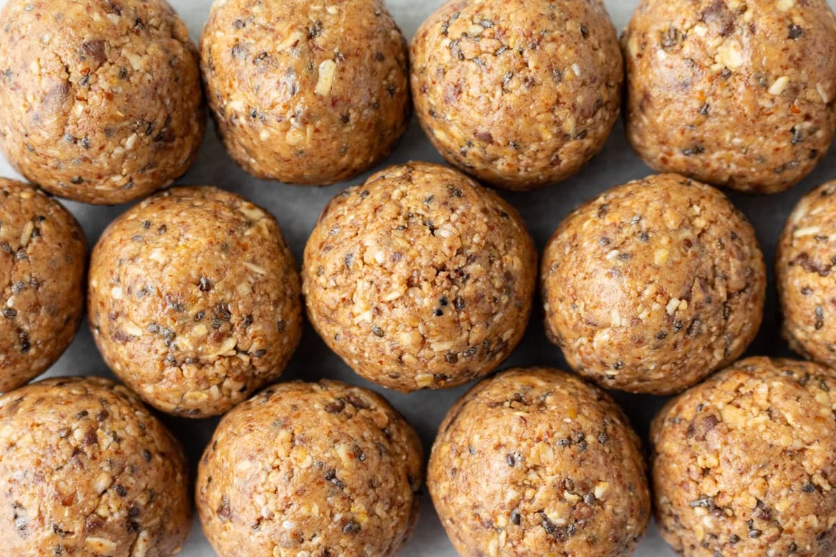 Close-up of multiple gluten free protein balls showing their textured surface with oats, seeds, and chocolate chips.