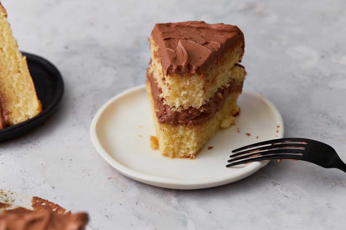slice of gluten free yellow cake being cut into with a fork