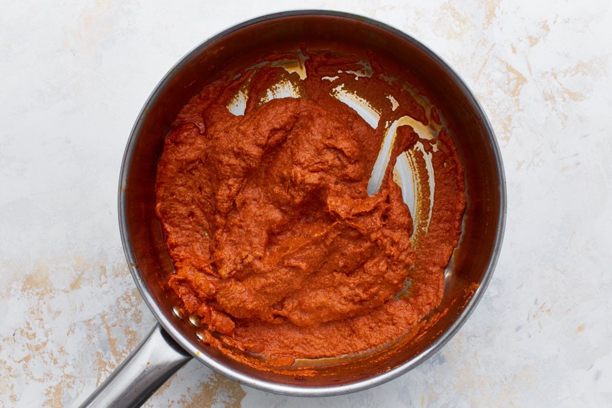 Thick tomato and vodka mixture in the skillet before cashew cream is stirred in.