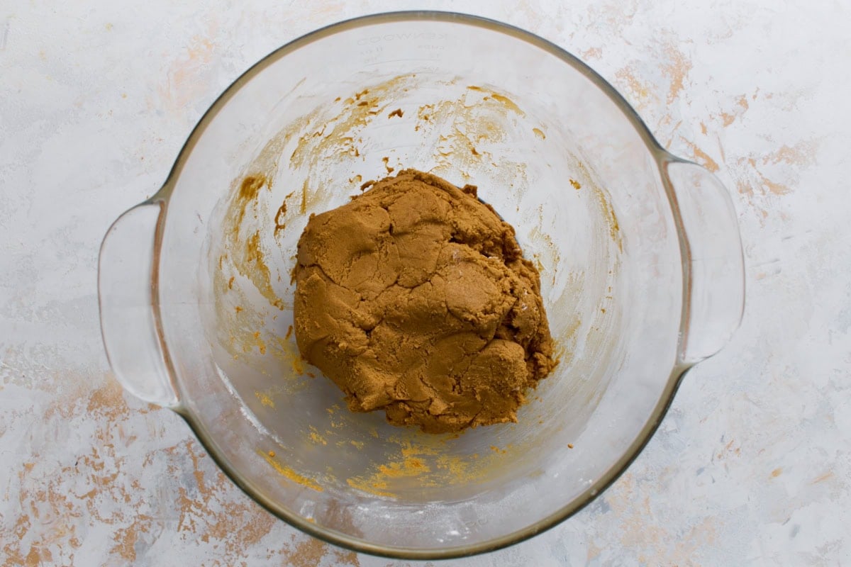 A glass bowl with the completed gingerbread dough, smooth and firm, ready to be chilled.