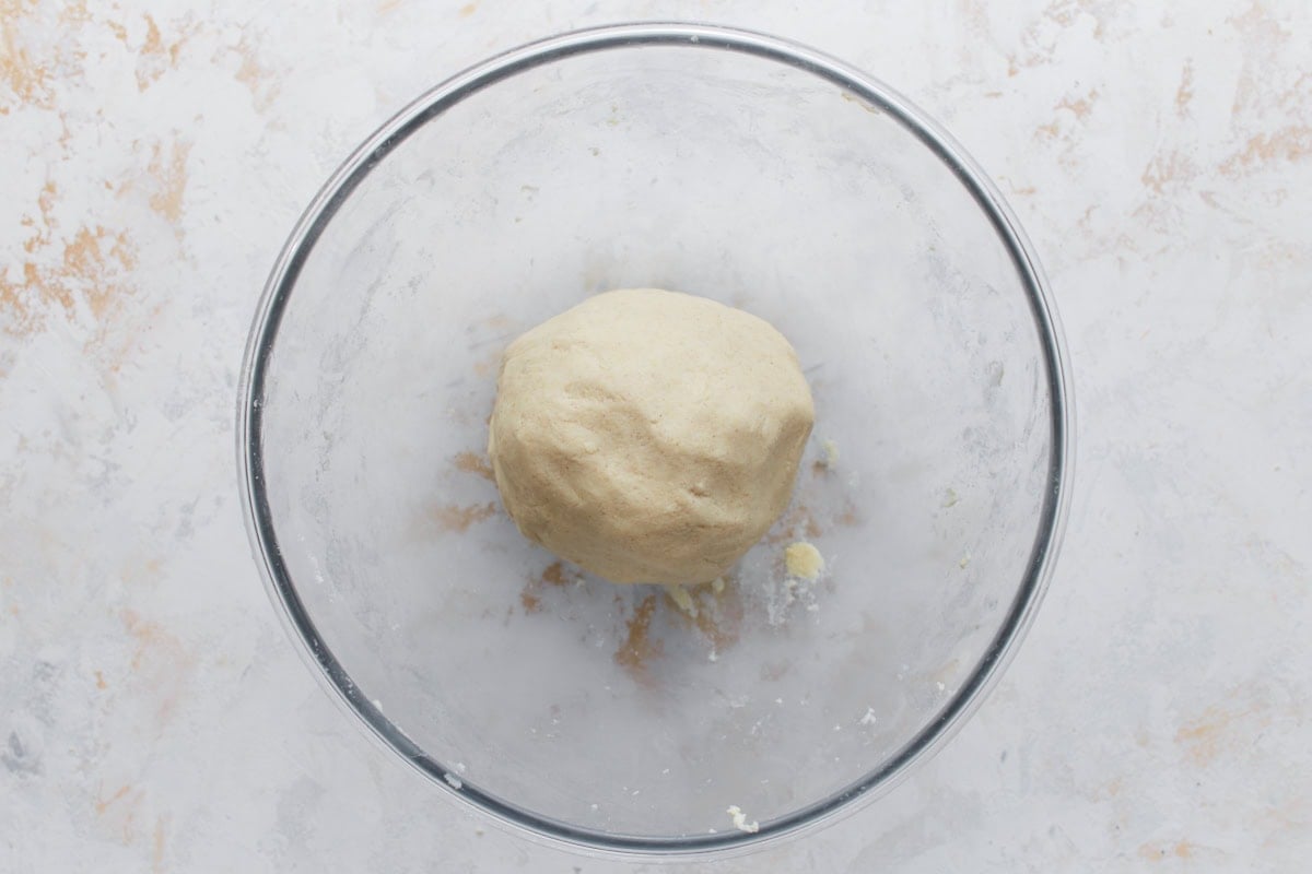 Smooth, rested ball of masa dough in a clear bowl, ready to shape into gorditas.