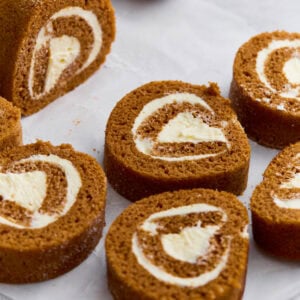 Close-up of gluten-free pumpkin roll sliced into swirls with cream cheese filling, dusted lightly with powdered sugar.