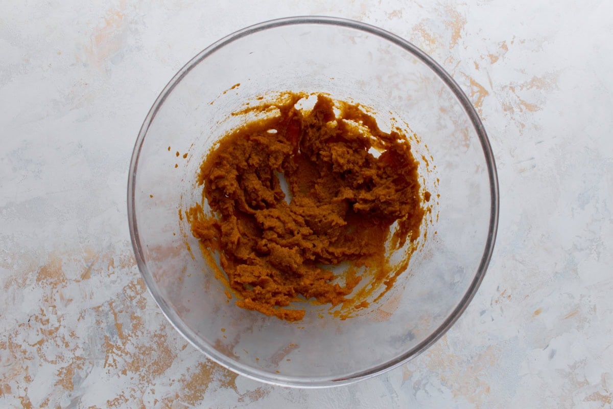 Glass mixing bowl with canned pumpkin puree mixed for waffle batter.