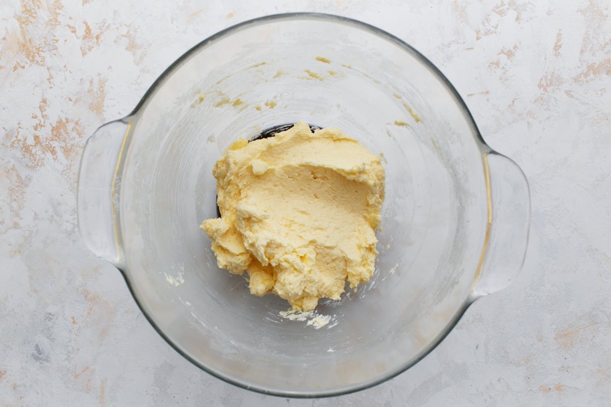 Smooth, pale yellow cookie batter after adding eggs and vanilla, showing the creamy consistency before dry ingredients are added.