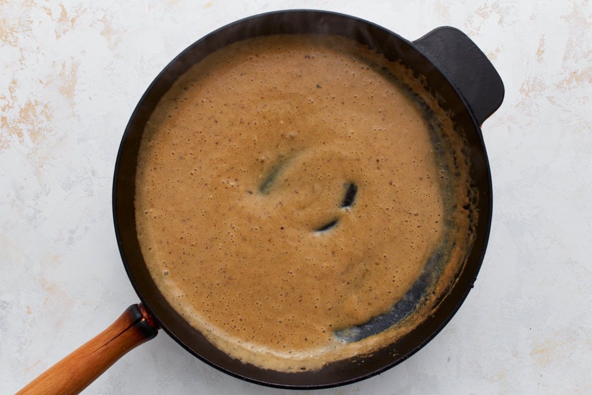 Creamy Swedish meatball sauce simmering in a skillet.