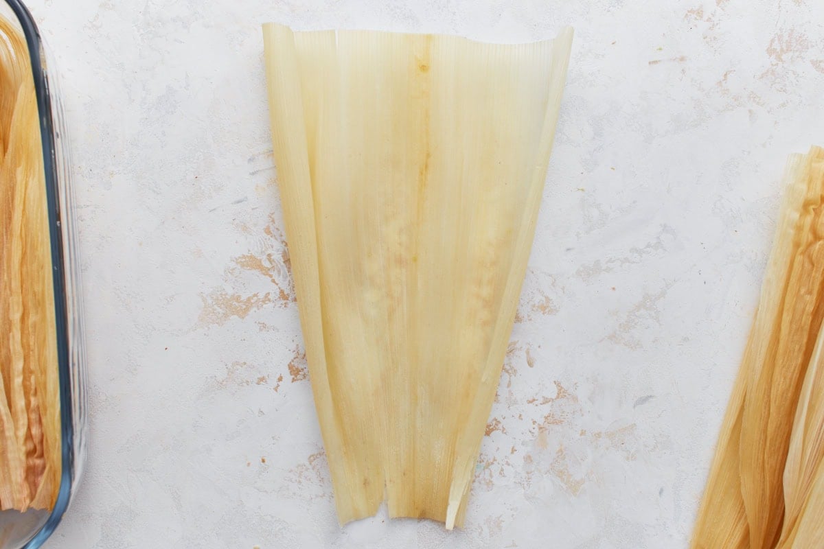 A single soaked corn husk laid flat and ready to fill.
