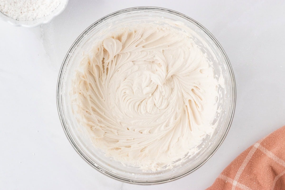 Smooth and fluffy dairy-free buttercream fully mixed in a glass bowl.