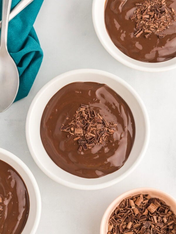 Bowls of rich dairy-free chocolate pudding topped with shaved chocolate, ready to serve.