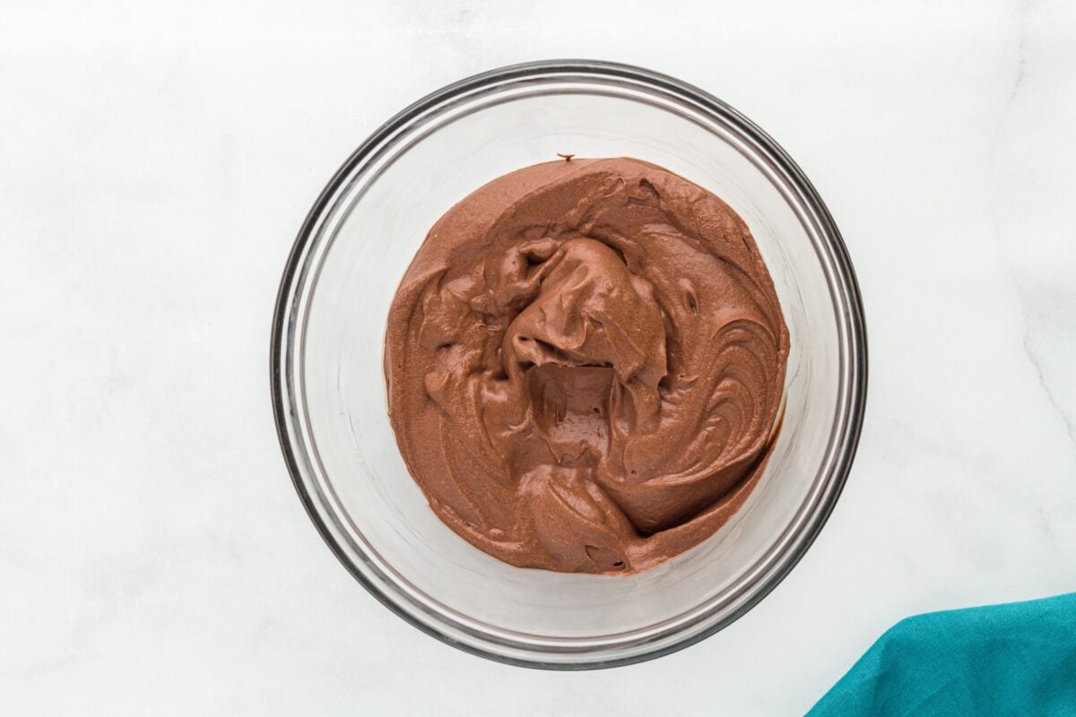 A glass mixing bowl filled with freshly whipped vegan chocolate mousse, showing a smooth and airy texture.