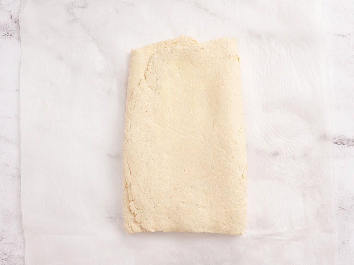 Gluten free dough folded into thirds like a letter after rolling, ready for the next chill.