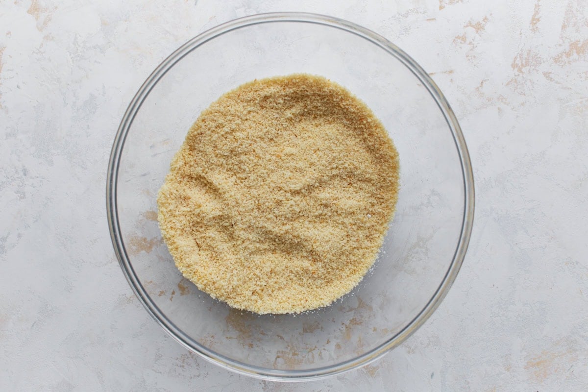 Dry ingredients for almond flour sugar cookies mixed together in a clear glass bowl.