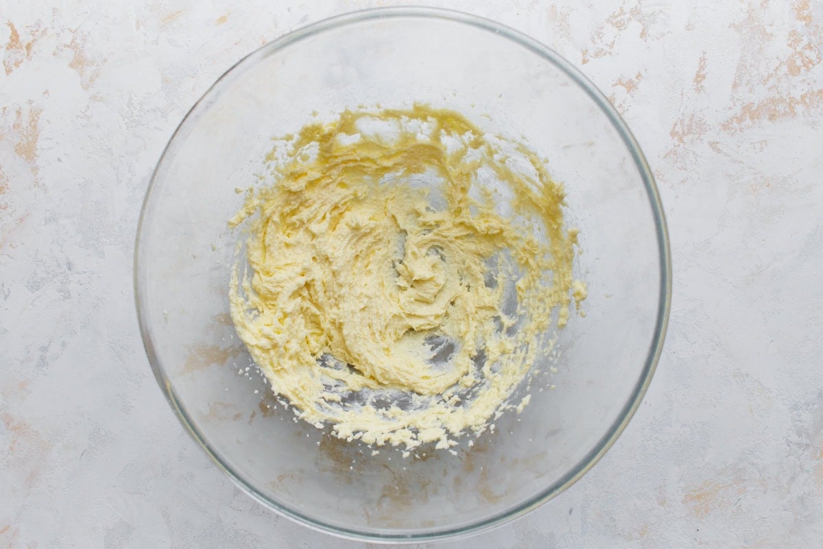 Creamed butter and sugar mixture in a glass bowl for almond flour sugar cookie dough.