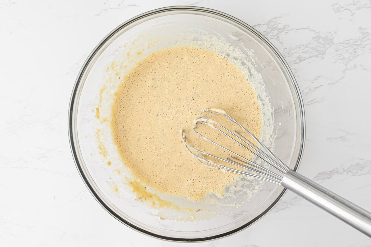 Chickpea pizza crust batter whisked smooth in a glass bowl