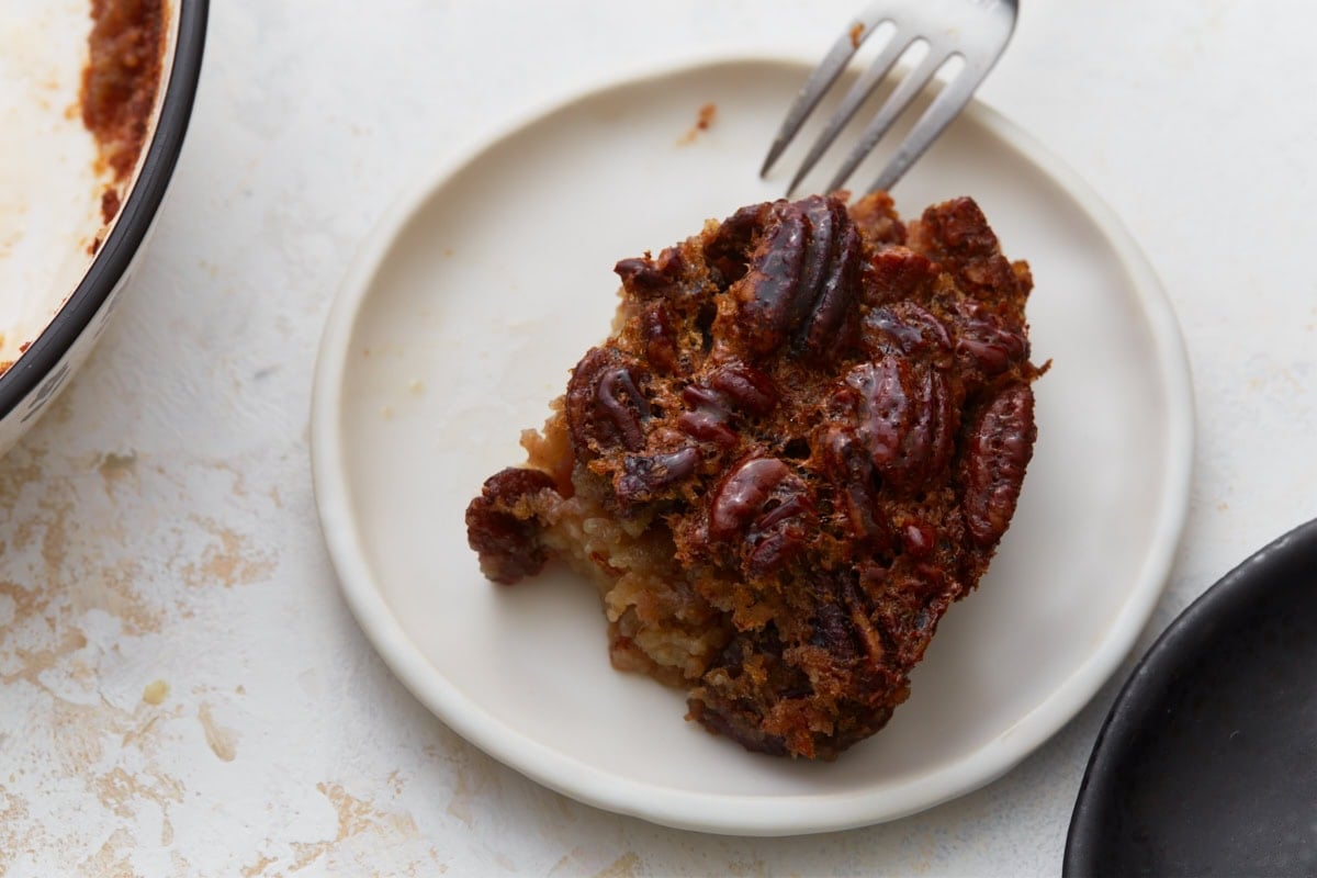 slice of crustless pecan pie on a plate with a fork being dipped into it