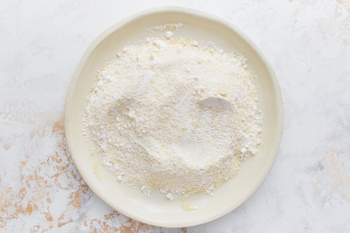 Plate filled with sifted almond flour and powdered sugar mixture for macaron batter.