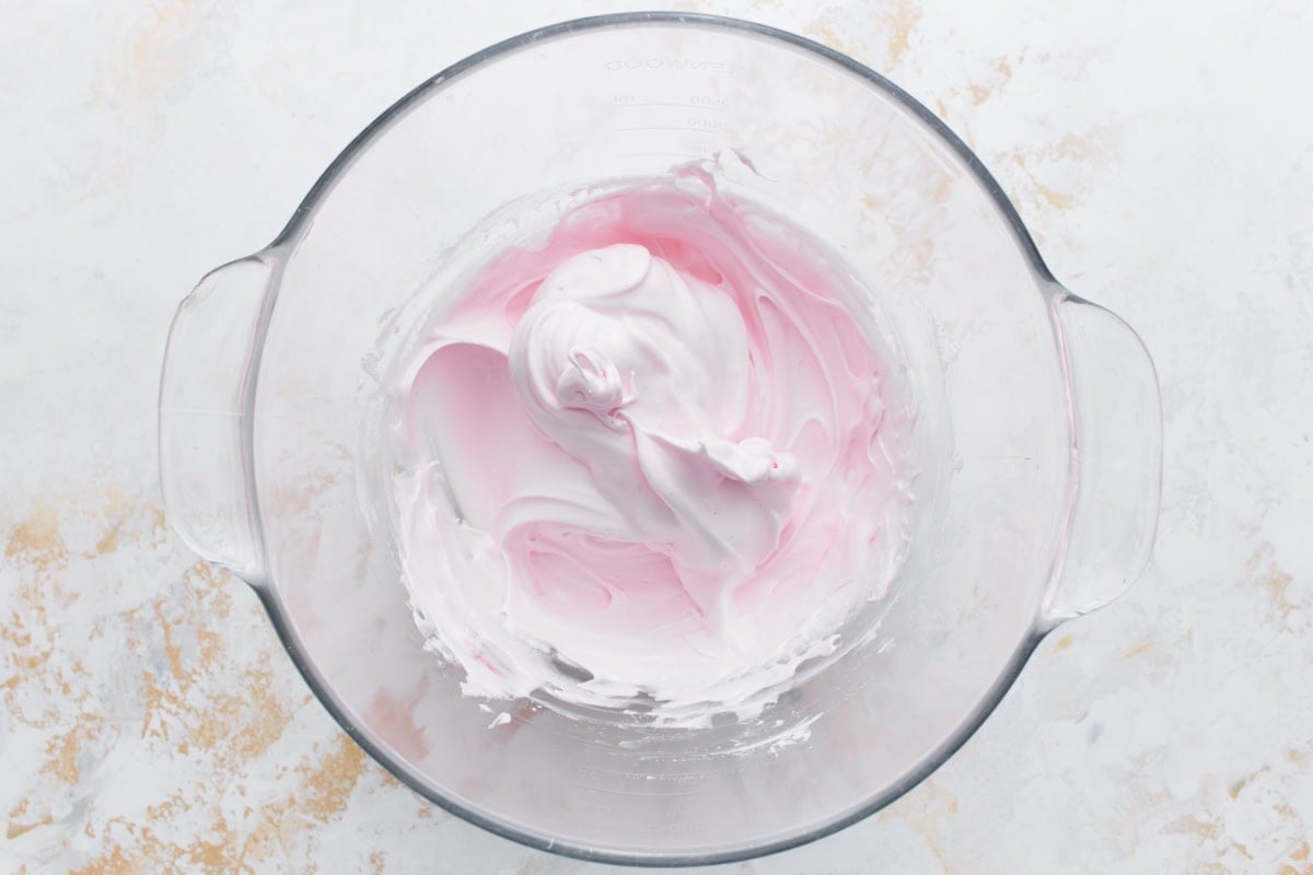 Pink-tinted meringue after adding vanilla and gel food coloring.