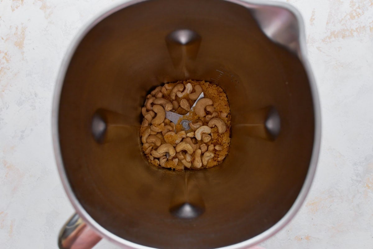 Raw cashews and seasonings in a high-speed blender before making vegan parmesan cheese.
