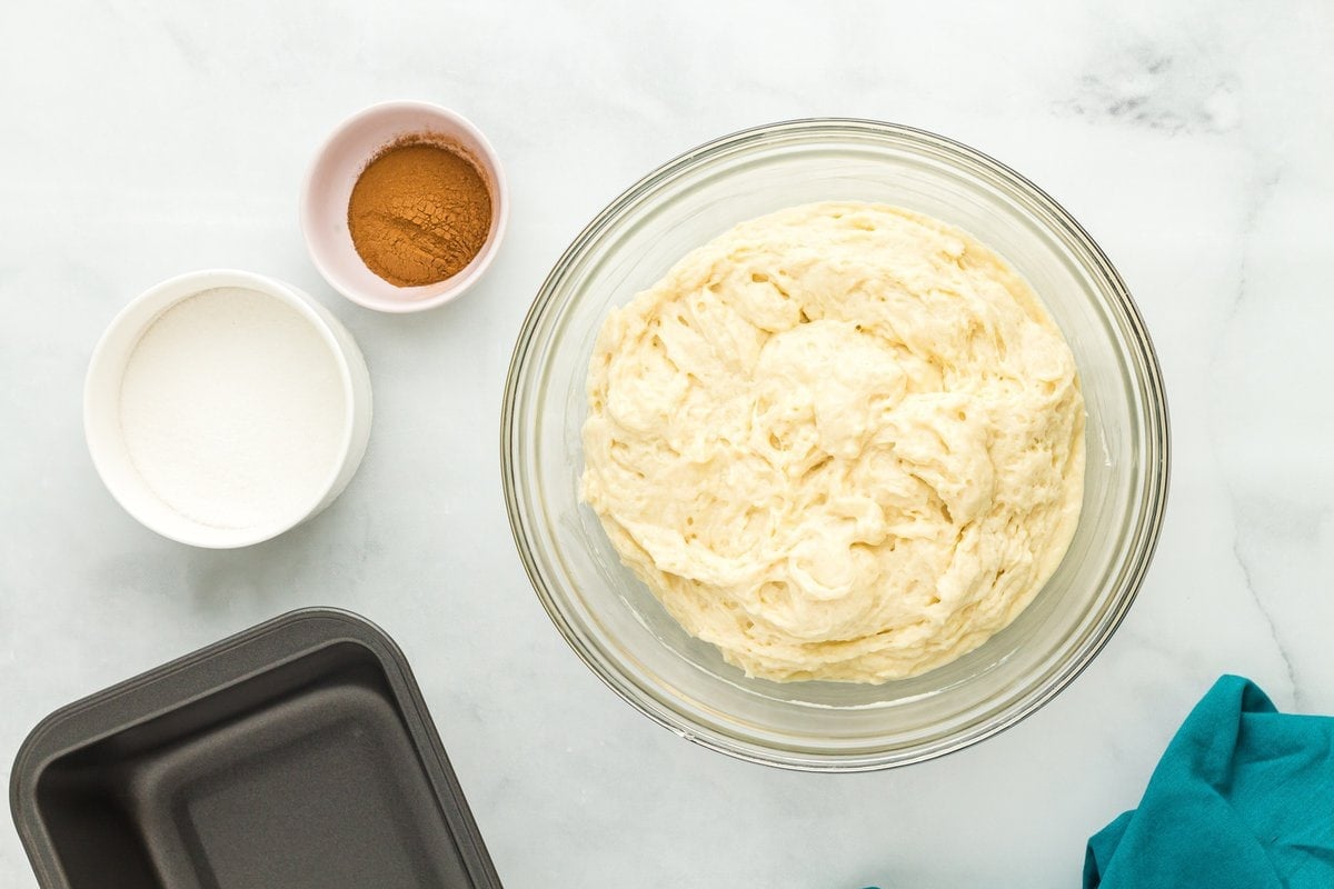 Bowl of cinnamon sugar next to prepared gluten-free cinnamon bread batter.