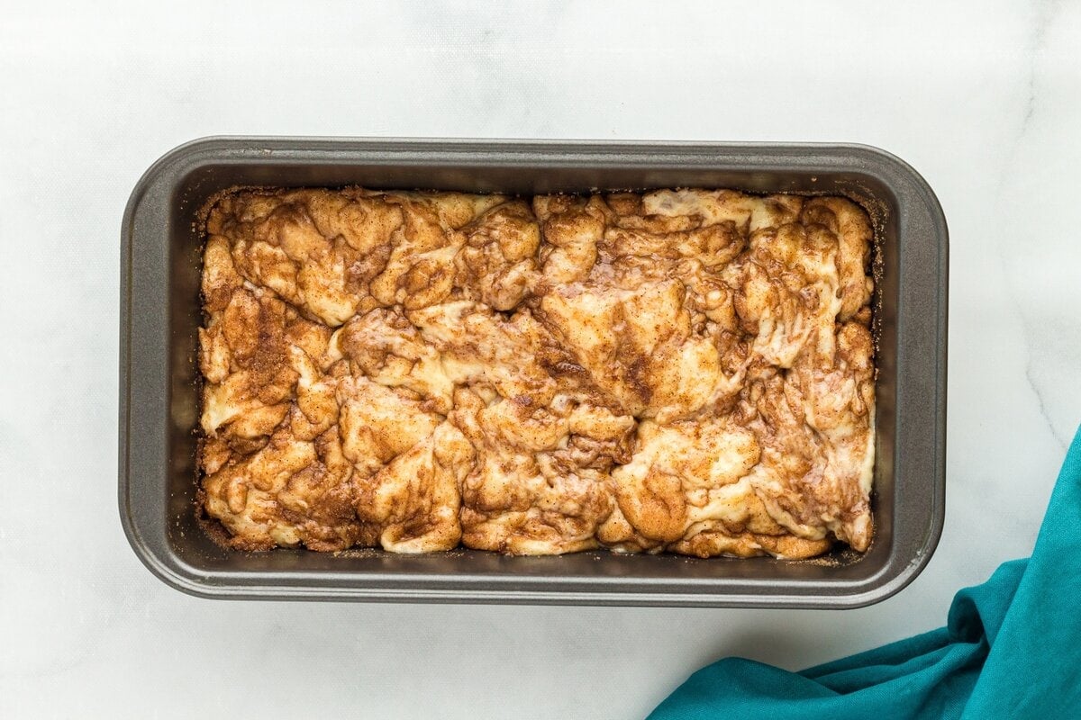 Cinnamon sugar swirled through gluten-free cinnamon bread batter in a loaf pan.
