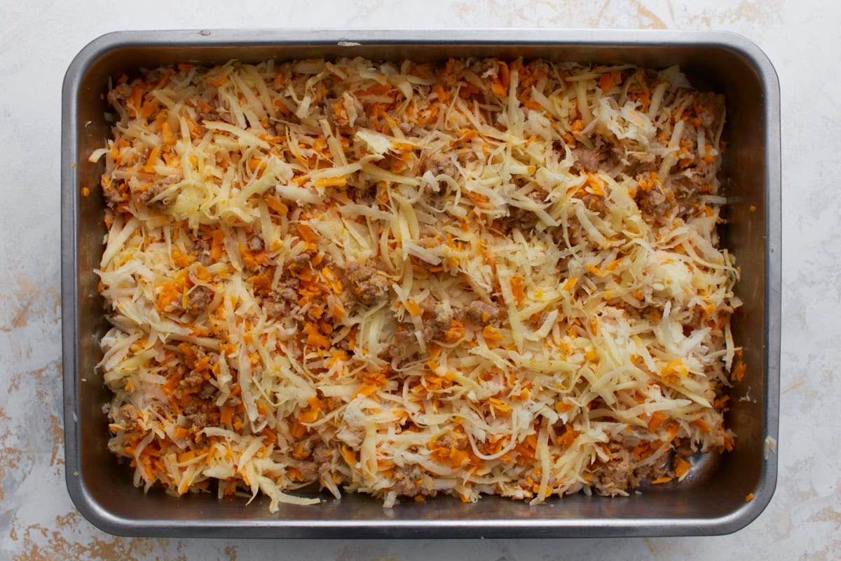 first layer of gluten-free breakfast casserole: hash brown potatoes and cheddar cheese