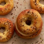 Keto bagels baked until golden brown and topped with everything bagel seasoning on parchment paper.