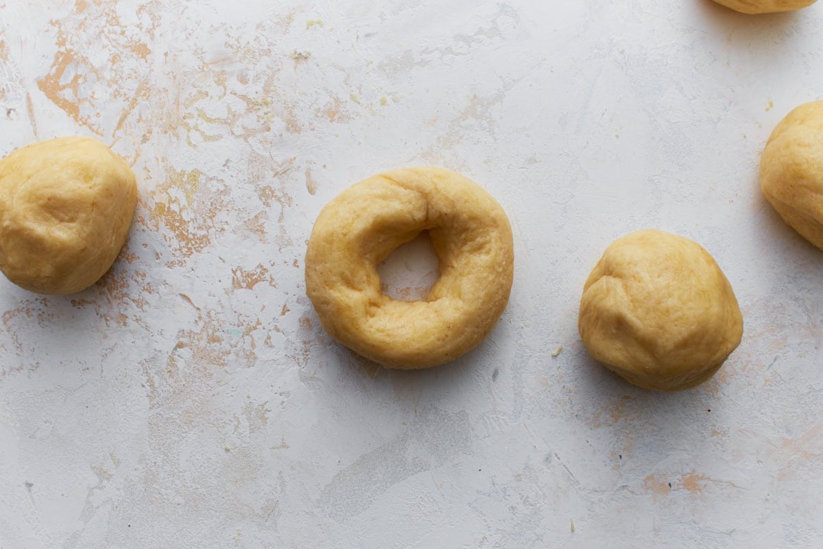 Portions of keto bagel dough shaped into rounds with holes in the center.