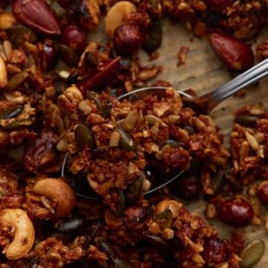 Close-up of baked keto granola clusters with mixed nuts and seeds, showing a crunchy texture and golden brown color.
