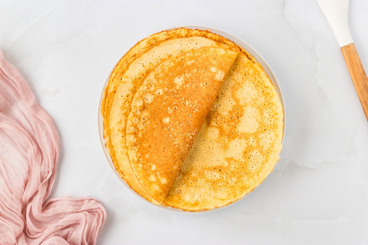 Cooked almond flour crepe folded in half on a white plate