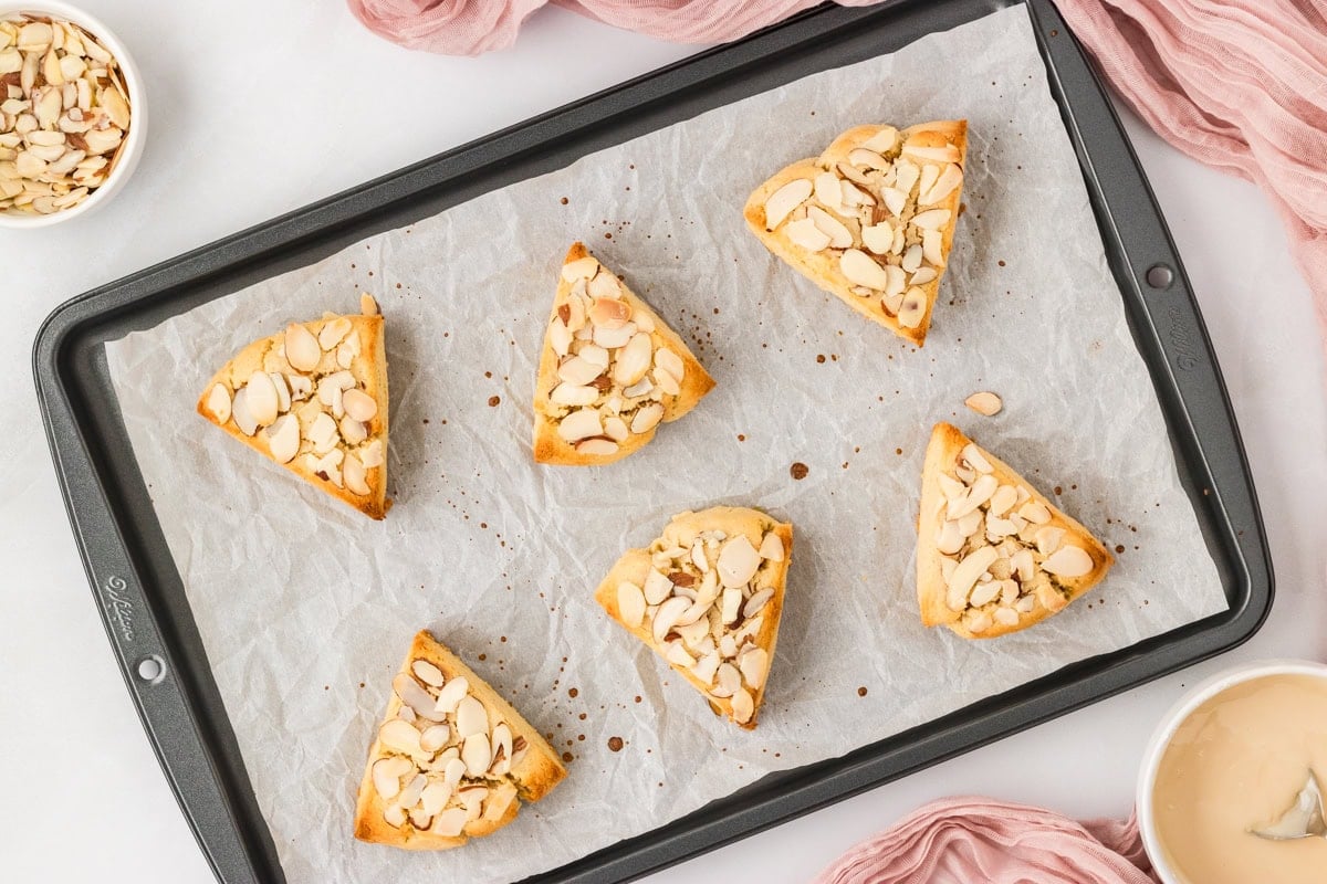 Baked almond flour scones with sliced almonds on parchment lined baking sheet