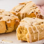 Close-up of almond flour scone with vanilla icing drizzle and sliced almonds showing soft crumb