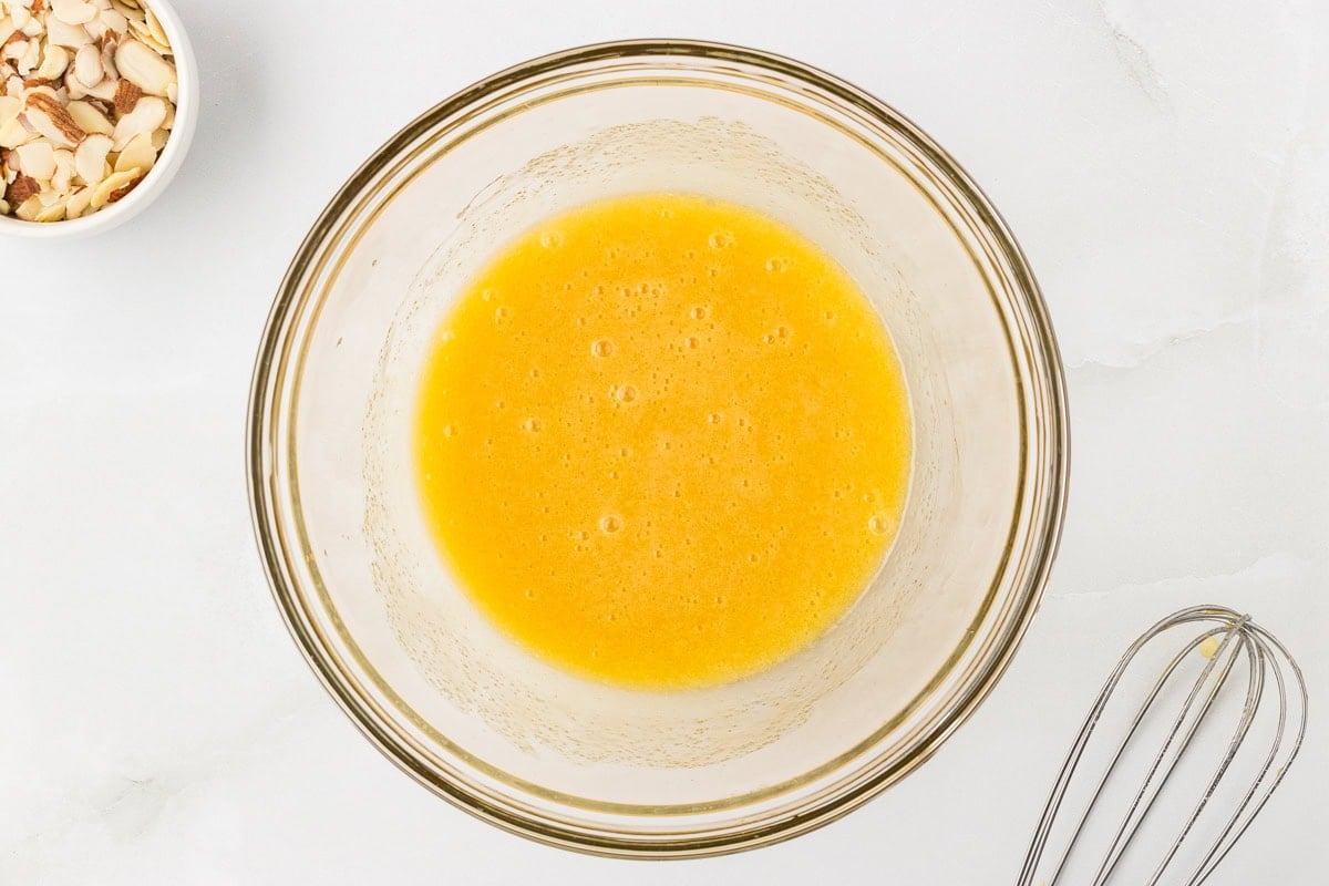 Melted butter, egg, and sugar mixture whisked smooth in glass bowl